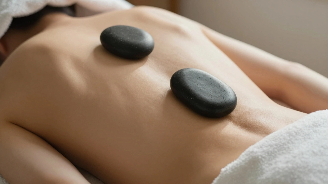 A heated stone resting along a spine on a massage table, glowing in soft golden light.