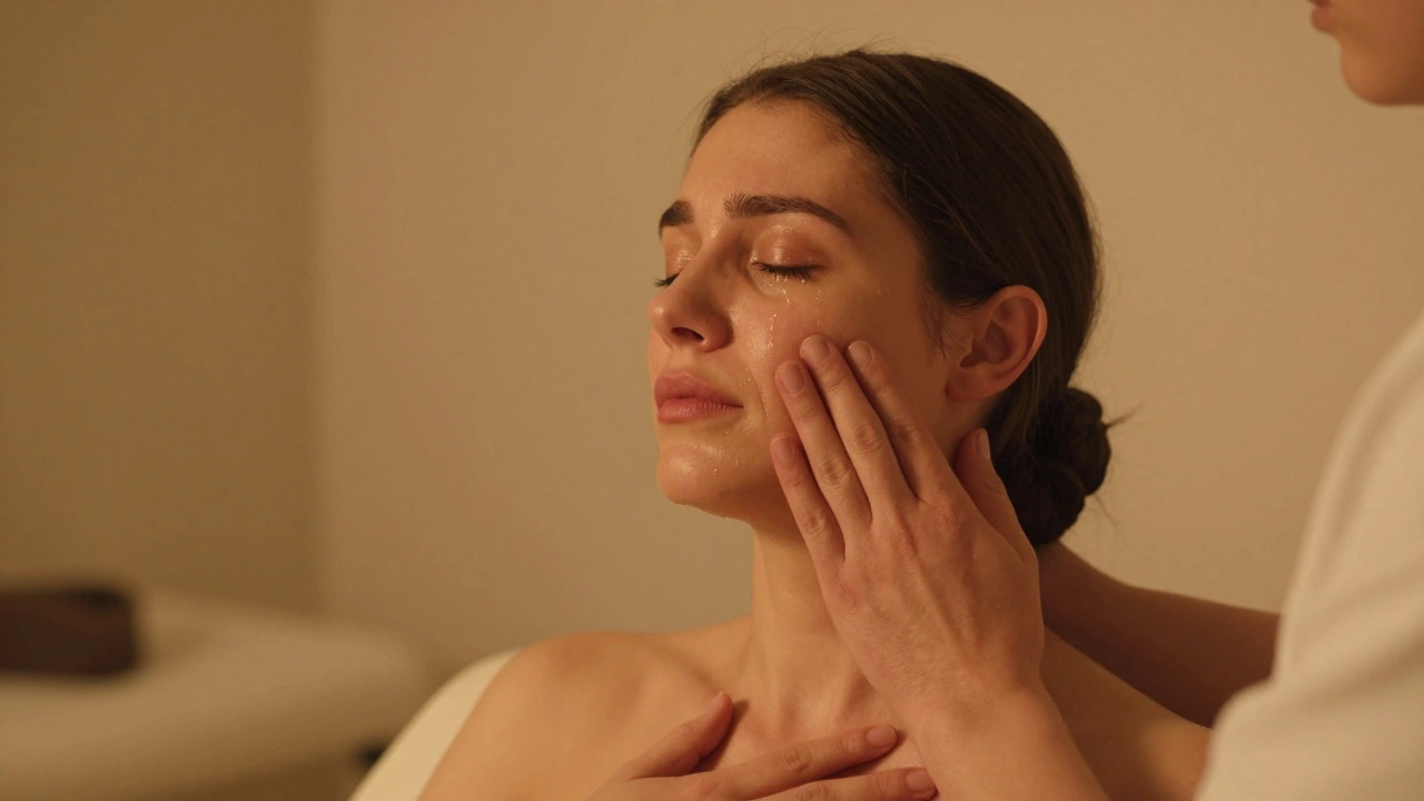 A woman crying peacefully during a tantra massage, tears on her cheek, hand on her chest, practitioner's hand resting safely on her shoulder.