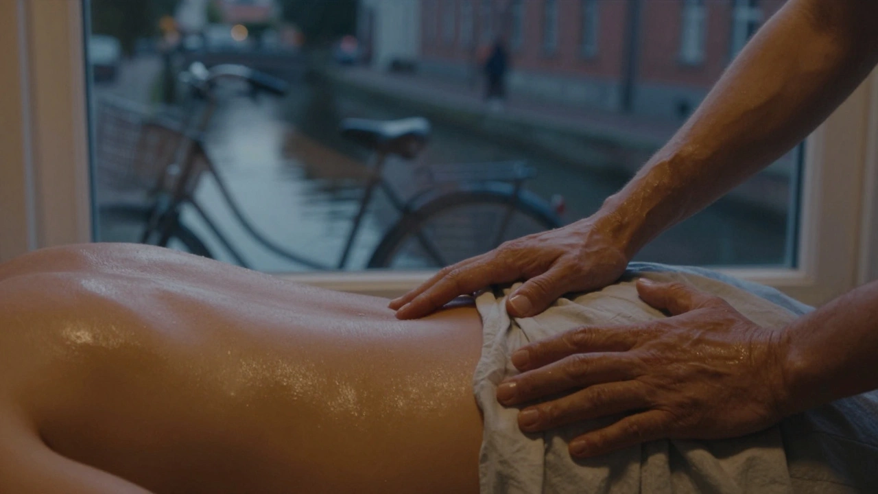 Close-up of therapist's forearm on client's hip, oil glistening, canal lights visible through window.